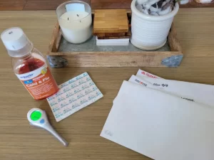 Cold and flu medicine, thermometer, and medical bills on a table – symbolizing unexpected expenses and the importance of saving and investing even without plans to retire.